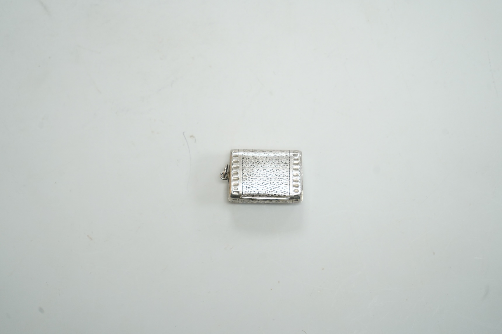 A late George III silver vinaigrette, modelled as a satchel, with pierced grille and sponge, John Shaw, Birmingham, 1818, 25mm.